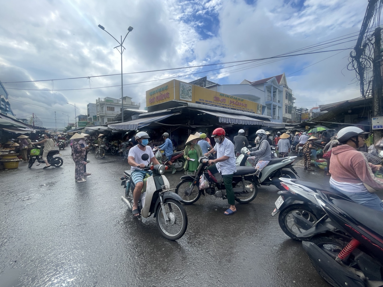市場周辺の交差点。人とバイクが合流し、分かれる。